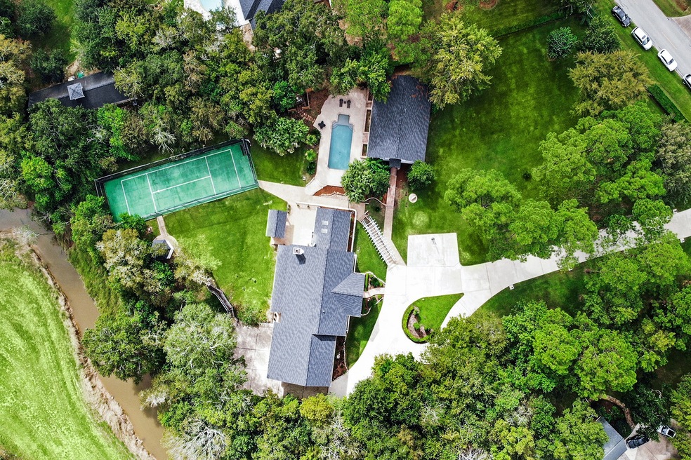 An aerial view of the property which is complete with a sport court, guest cottage, and pool area.