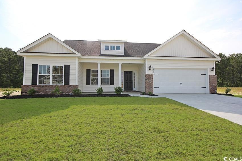 View of front of house featuring brick siding, driveway, and board and batten siding