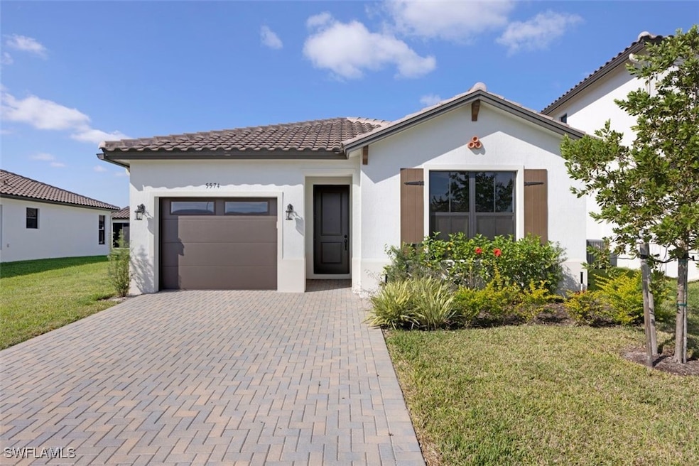 Mediterranean / spanish-style home featuring a gar