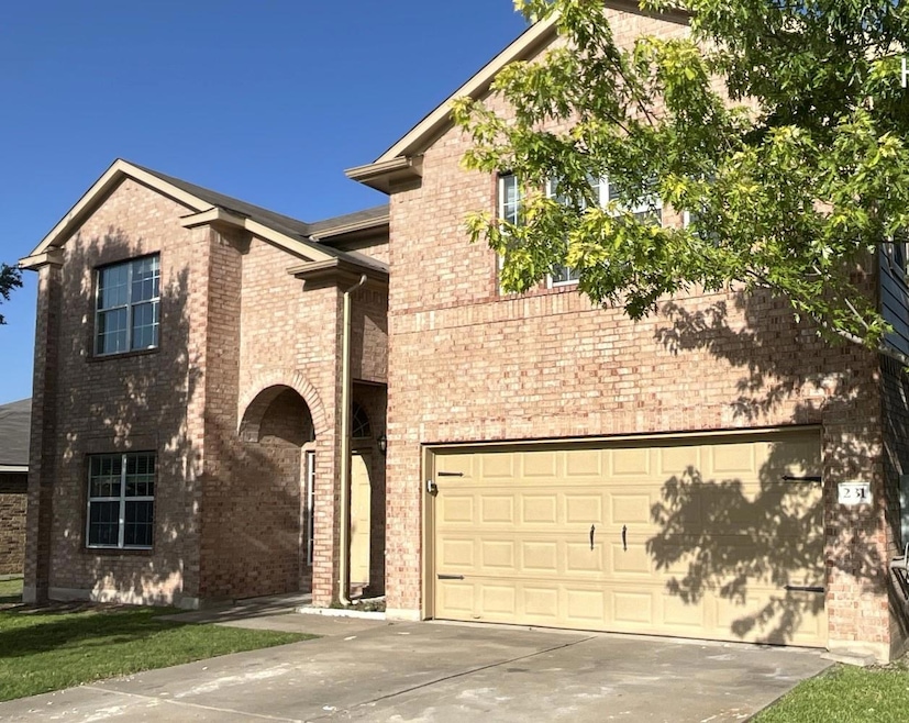 View of front of home featuring brick siding, concrete driveway, and an attached garage