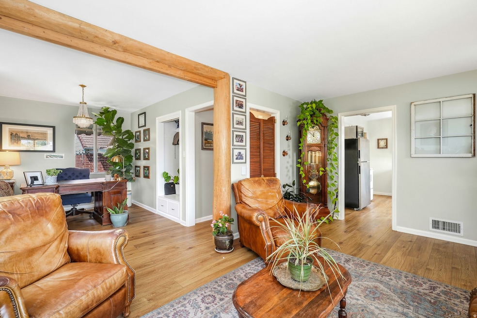 Living area featuring wood finished floors, an office area, and beam ceiling