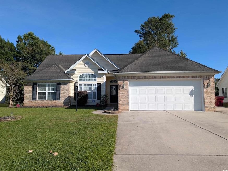 Ranch-style home with a front yard, brick siding, concrete driveway, a garage, and a shingled roof