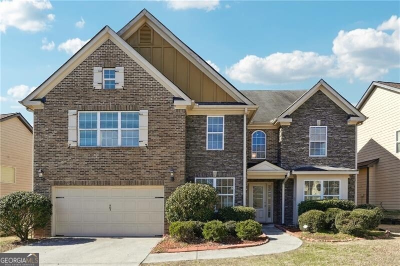 Traditional home featuring a garage, brick siding,
