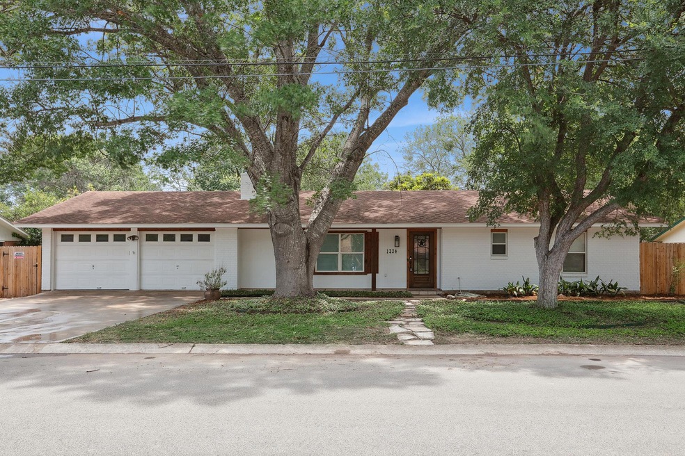 Single story home featuring driveway, a garage, b