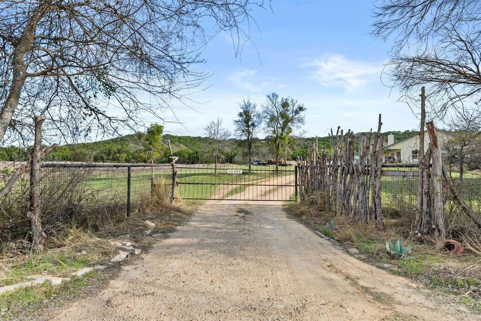 View of road with dirt driveway, a gate, and a ga