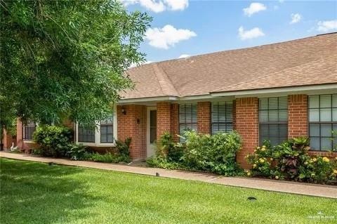 Single story home featuring brick siding and a front lawn