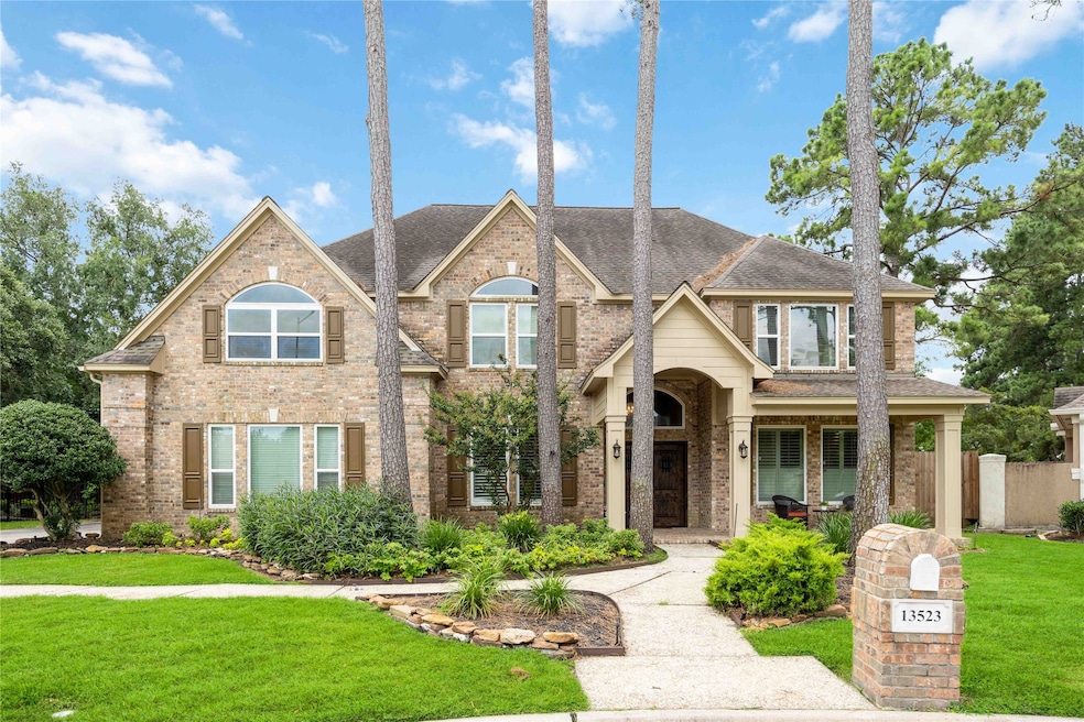 Two-story brick home in Lakewood Oaks Estates with tall trees and a manicured lawn.