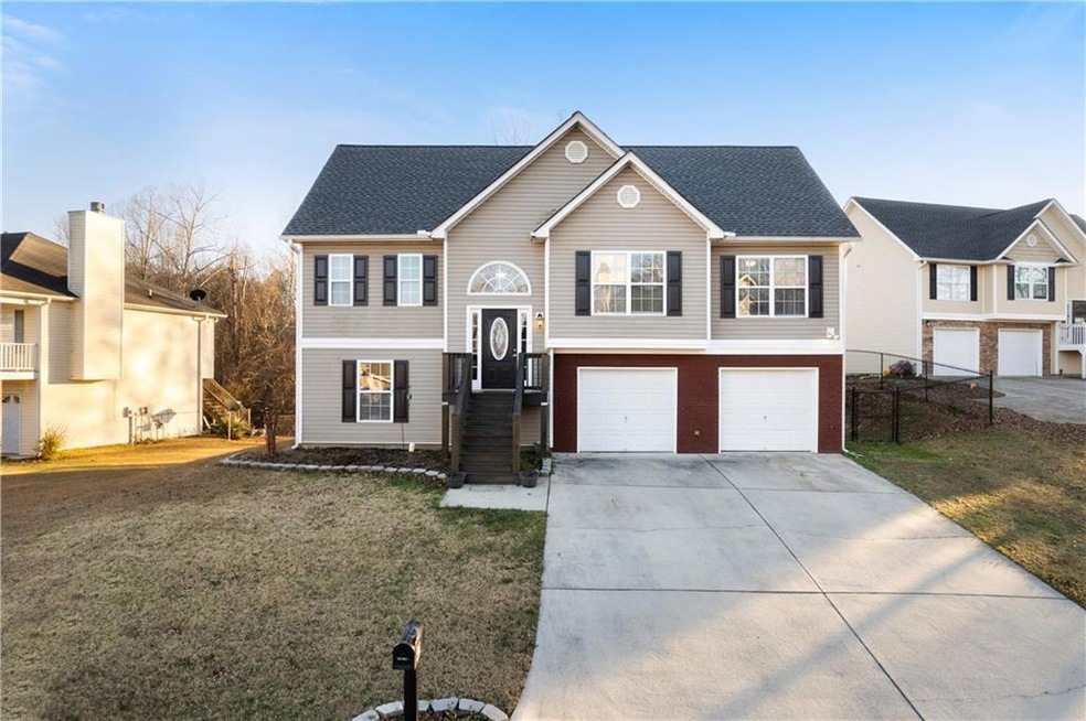 Split foyer home featuring a garage and a front ya