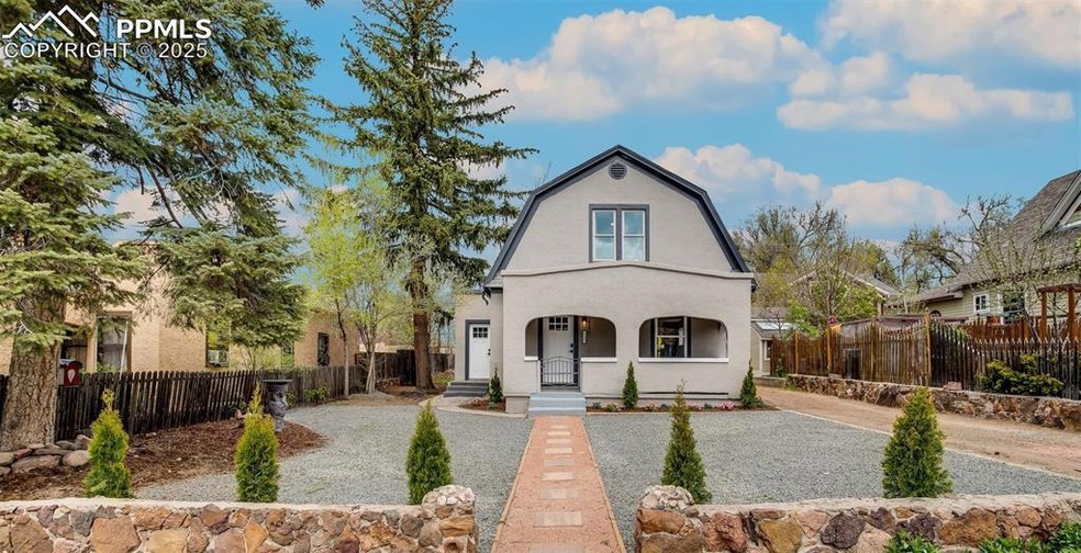 Colonial inspired home with covered porch, a fence