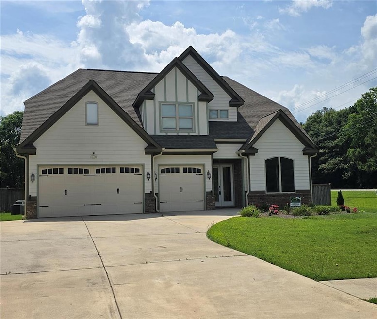 View of front of house featuring a garage, a shing