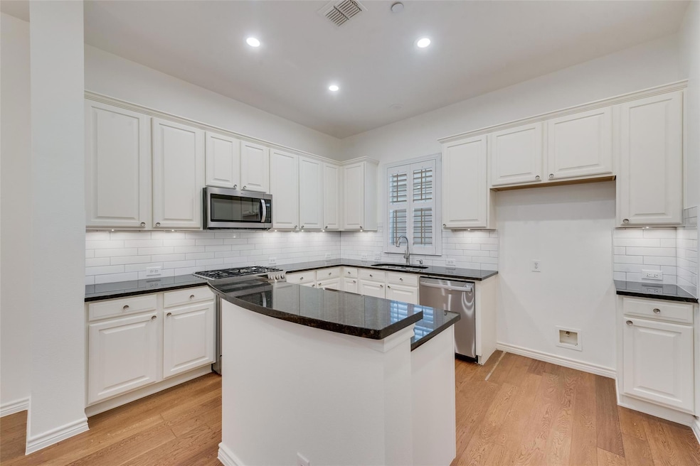 Kitchen with stainless steel appliances, a sink, v