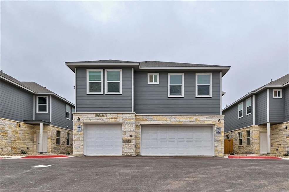 View of front of property with driveway, stone si