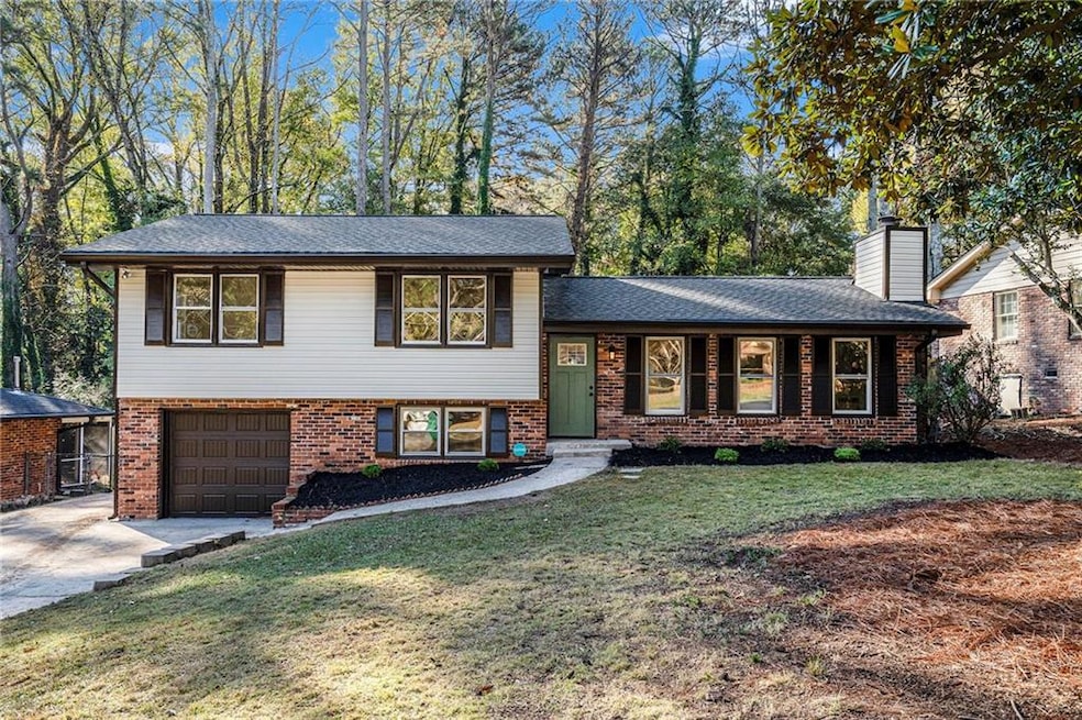 Split level home featuring a garage and a front ya