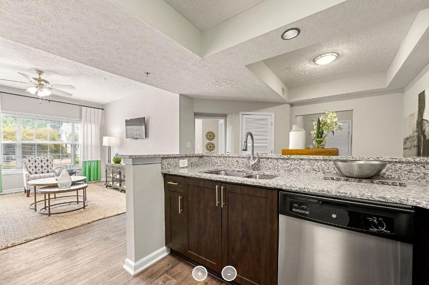 Kitchen featuring dishwasher, dark brown cabinets,