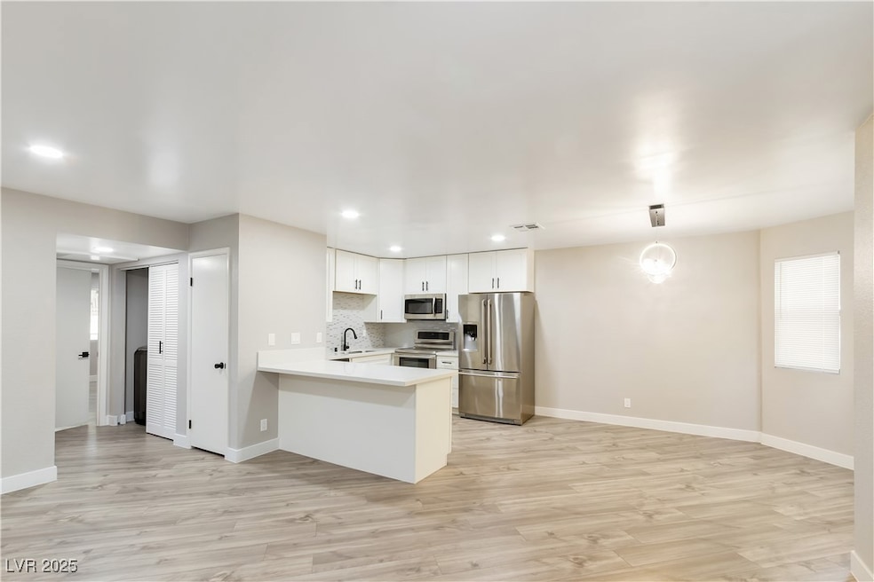 Kitchen featuring a sink, light countertops, appli