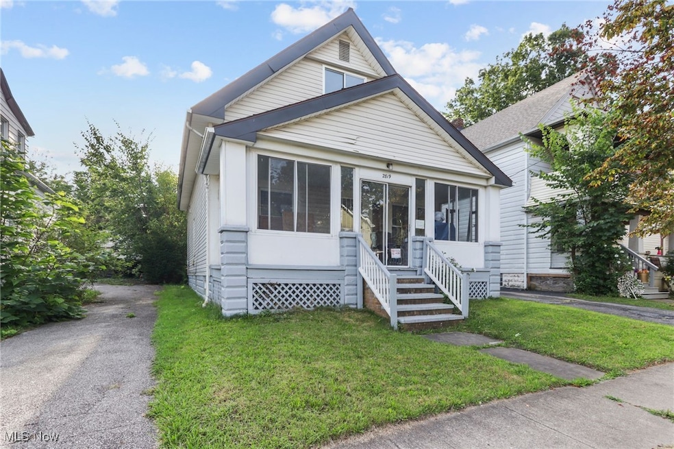 Bungalow-style house featuring a sunroom, a front yard, and entry steps