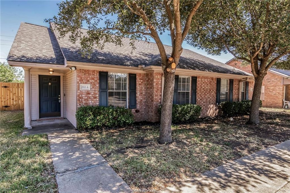 Ranch-style house featuring brick siding and a shi