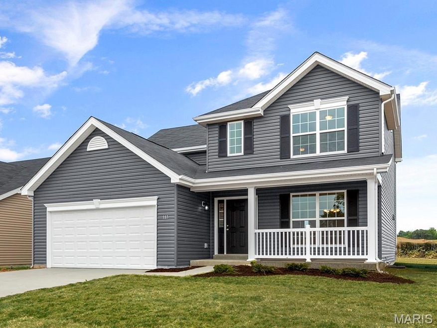 Traditional home featuring a porch, a front yard, driveway, and a garage