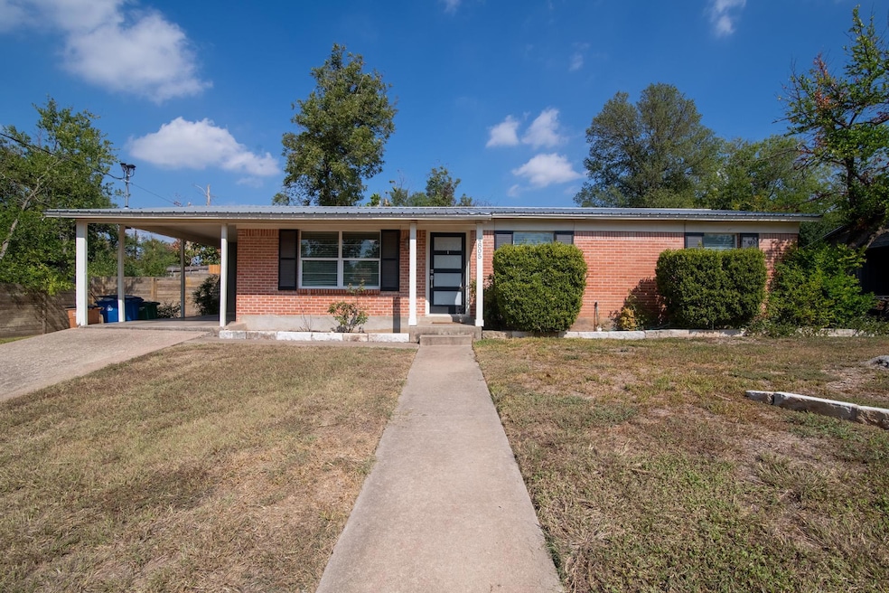 Ranch-style house featuring a carport, a front lawn, brick siding, driveway, and covered porch