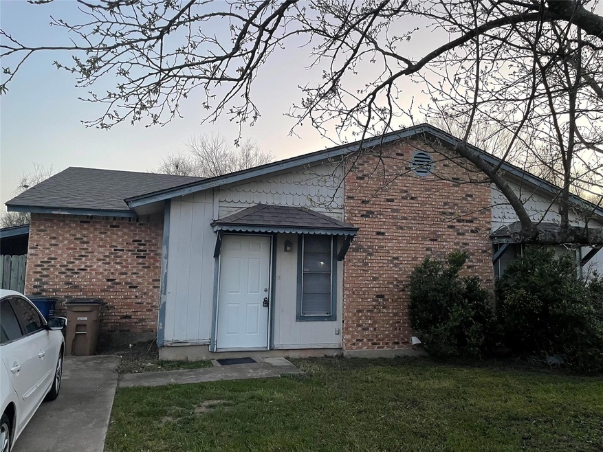 Back of house with a yard, brick siding, and a sh