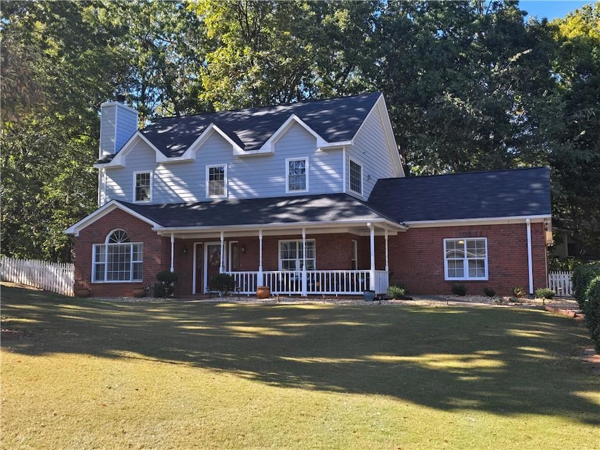 Traditional-style house featuring covered porch, a chimney, and brick siding