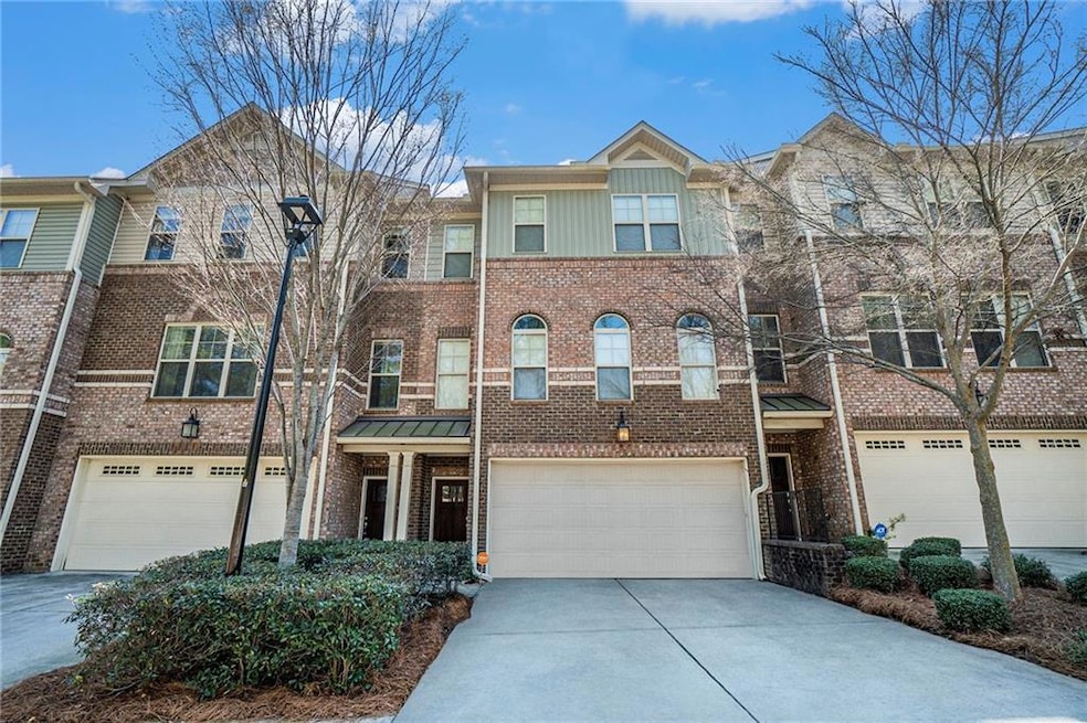 View of property featuring concrete driveway, a ga