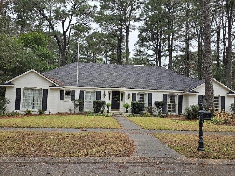 Ranch-style home featuring a front lawn and roof w