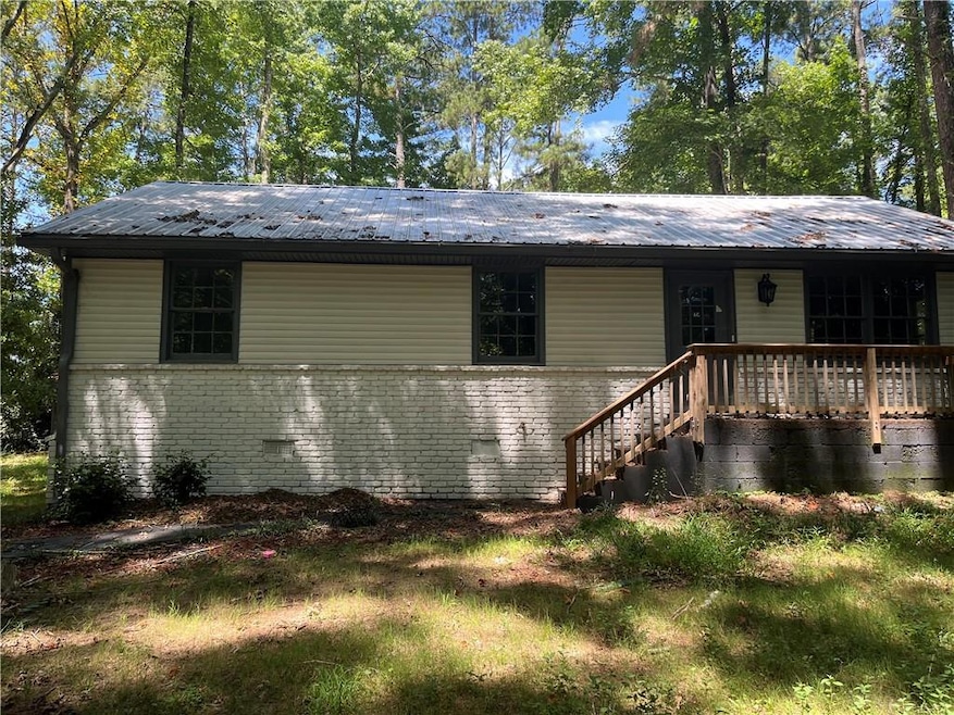 View of front of house featuring brick siding and a metal roof