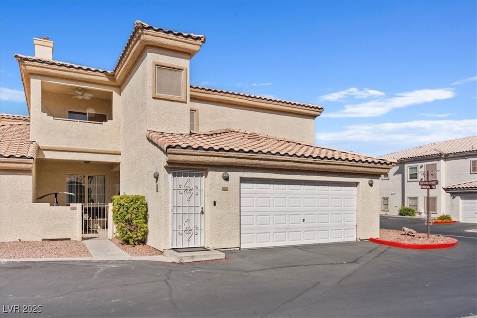Mediterranean / spanish-style home featuring a chimney, stucco siding, asphalt driveway, and a tile roof