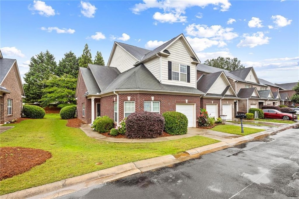 View of front of property featuring driveway, a garage, brick siding, a front yard, and roof with shingles