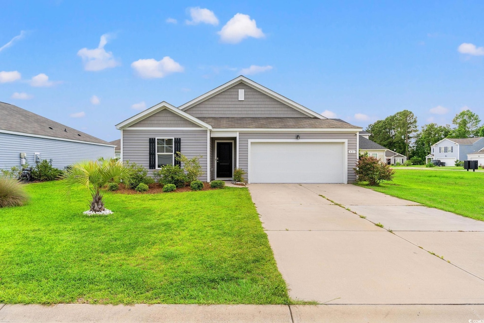 View of front of home featuring a front yard, a garage, and concrete driveway