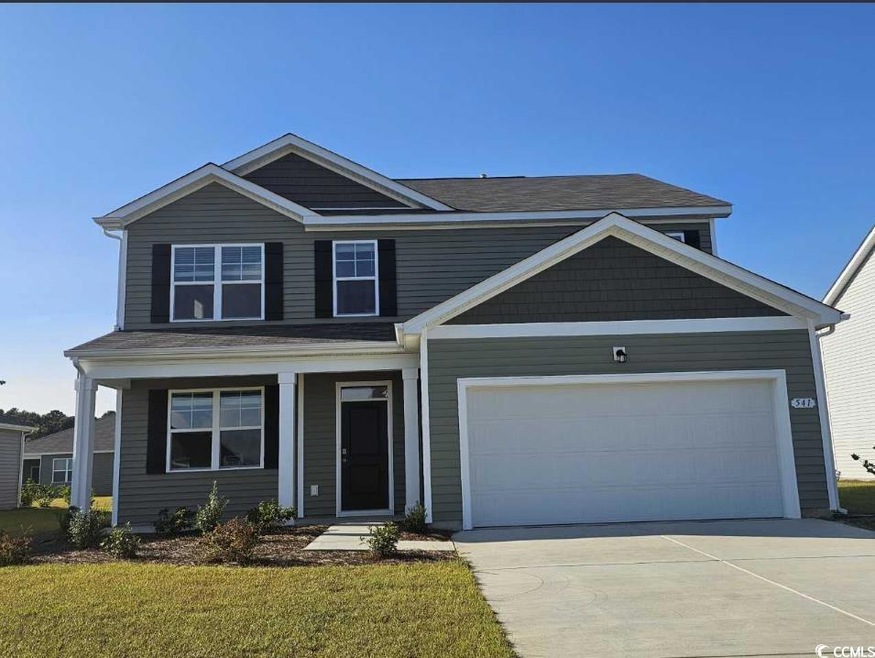 View of front of home with a front yard and a gara