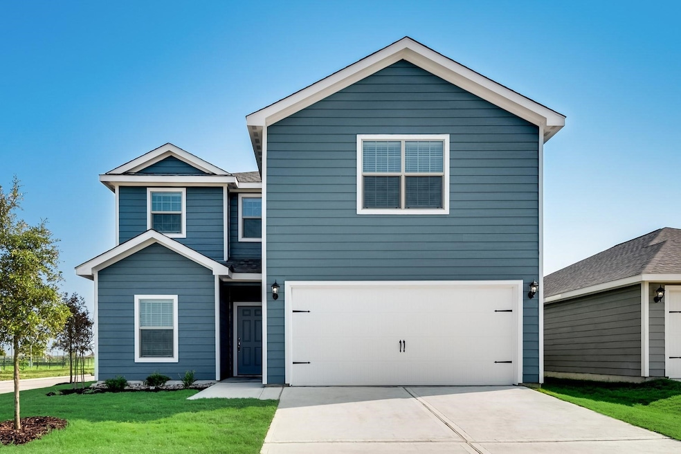 View of front of home with a front yard, driveway, and a garage