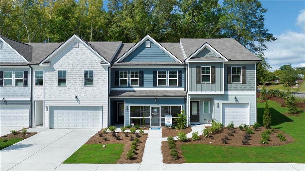 View of property featuring a front lawn and a gara