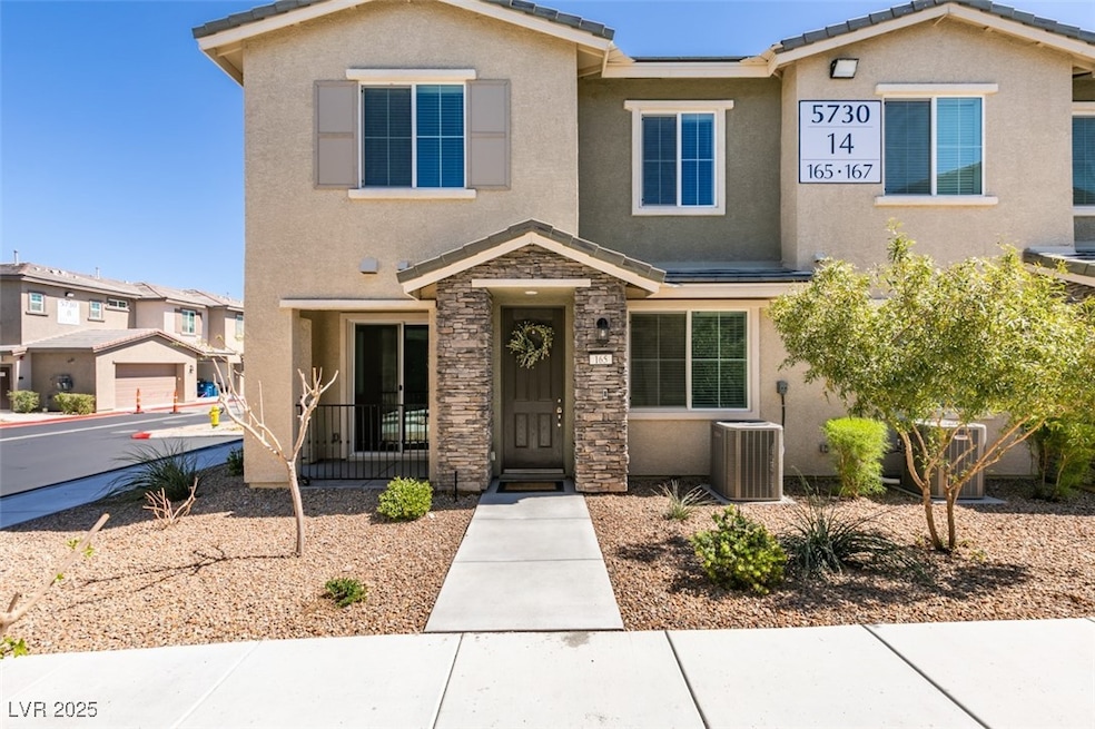 View of front of home featuring a tile roof, stucco siding, and central AC unit
