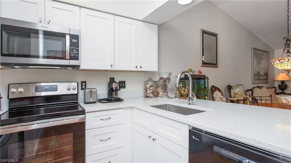 Kitchen featuring white cabinetry, stainless steel