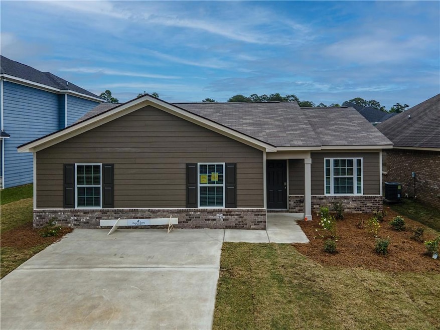 View of front of home with brick siding, a front yard, central AC, and a shingled roof