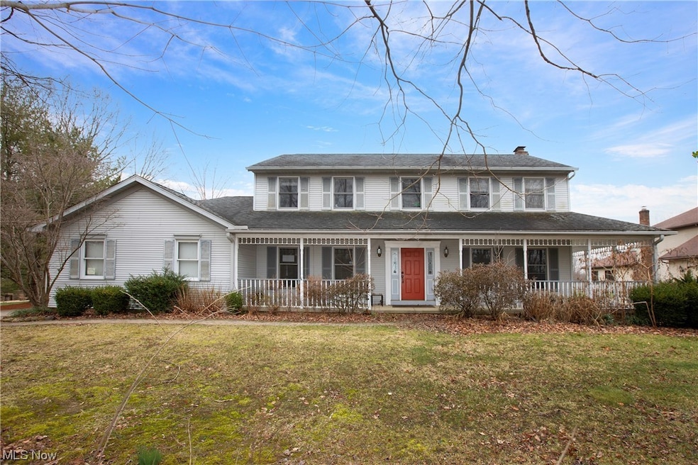 View of front facade with covered porch and a front yard