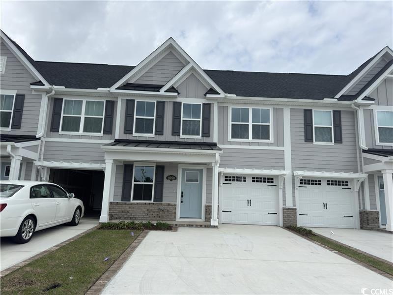 View of property with brick siding, concrete drive