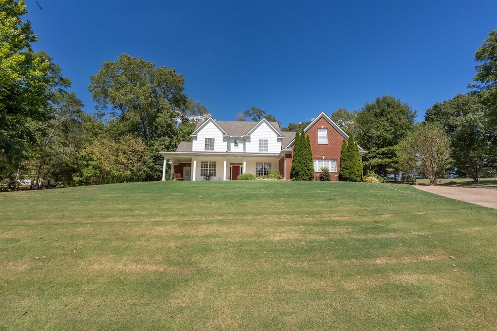 View of front facade with a front yard and covered