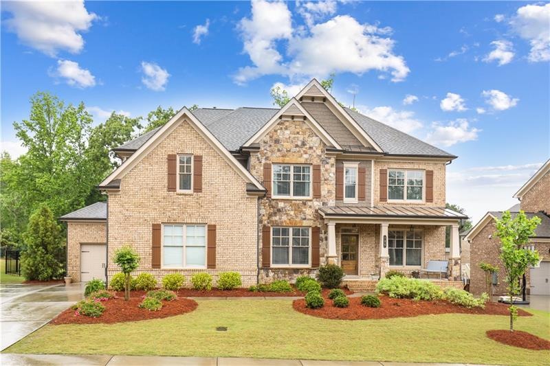 Brick and Stone Beauty with 3 car garage. Covered 