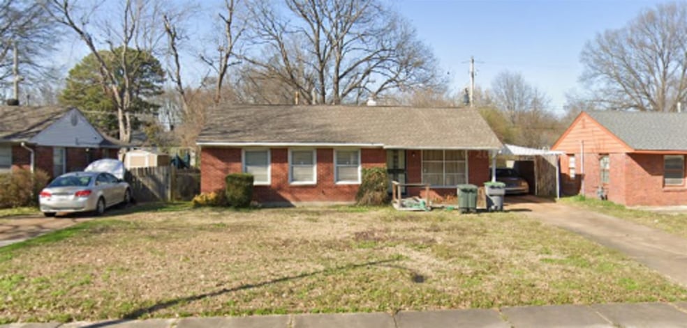 Single story home featuring asphalt driveway, a front lawn, an attached carport, and brick siding