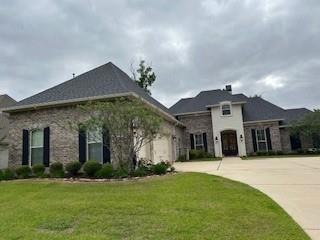 French country inspired facade with a front yard