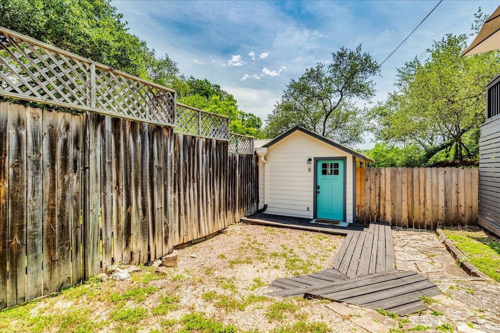 Fenced backyard with a storage unit and an outbui