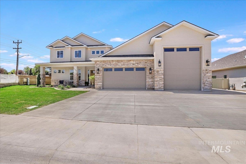 View of front of home with a garage, driveway, stone siding, a porch, and stucco siding