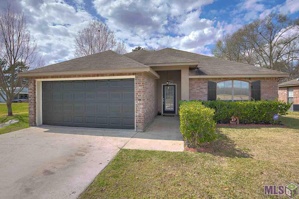 Front of home with long driveway, two car garage, 