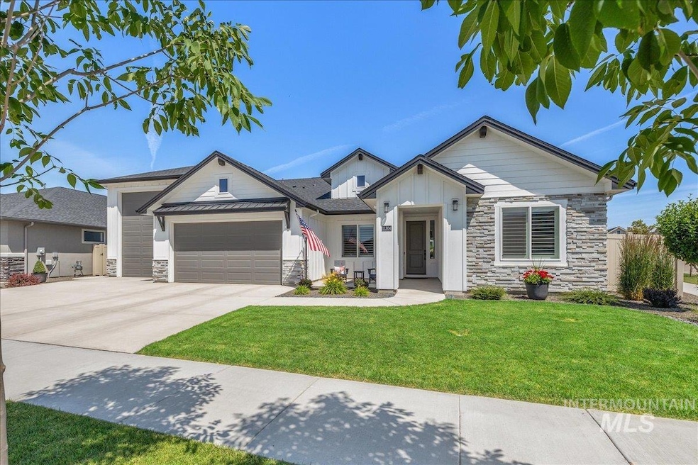 View of front of property with stone siding, a garage, board and batten siding, and concrete driveway