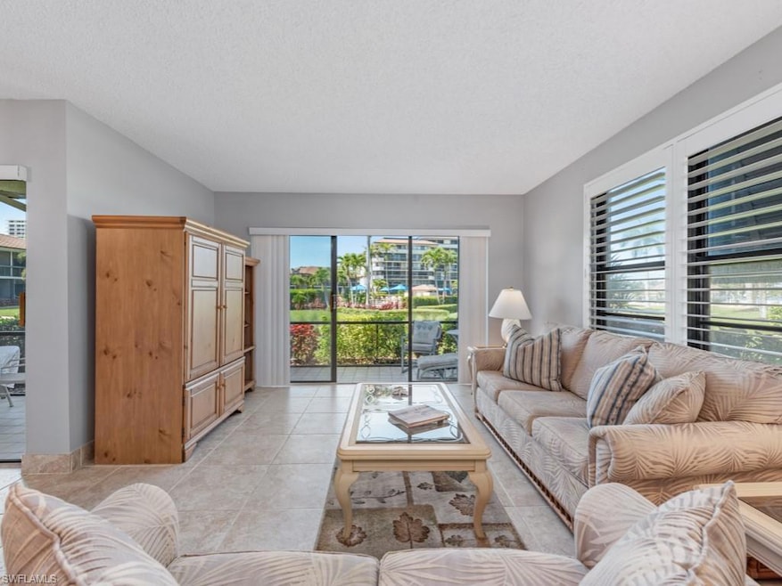 Living area featuring light tile patterned flooring and a textured ceiling