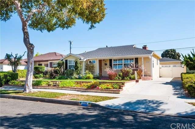 Welcoming west facing exterior has small lawn, roses, terraced garden.