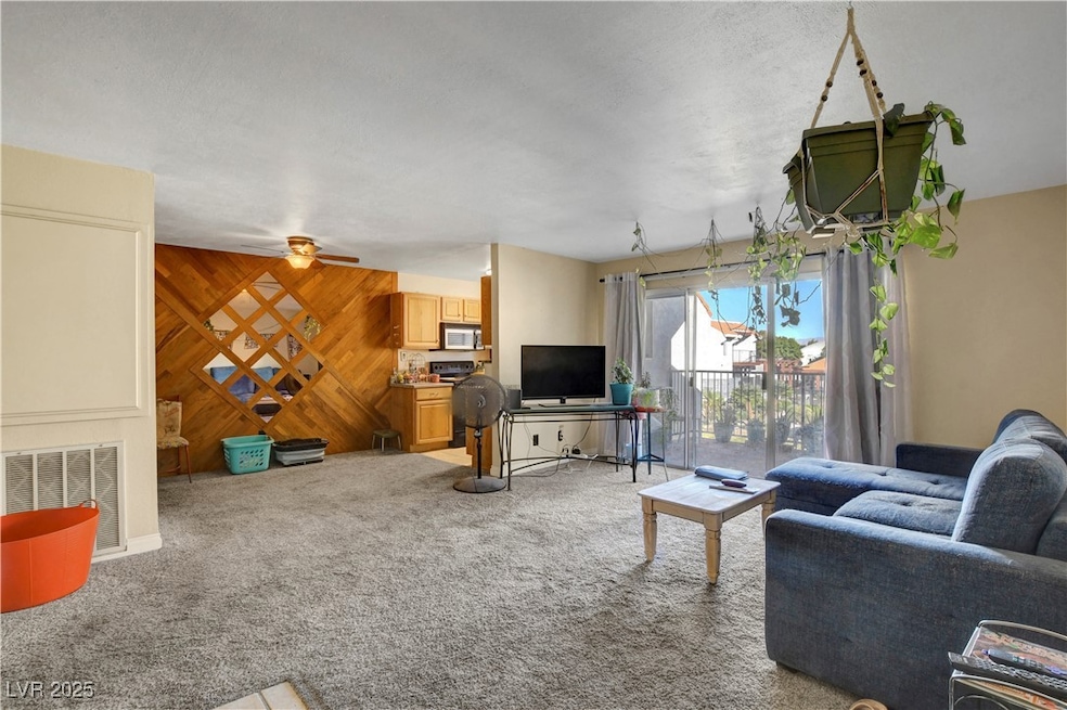 Living room with wooden walls and light colored carpet